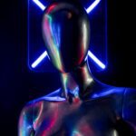 A metallic mannequin illuminated by vibrant neon blue lighting.